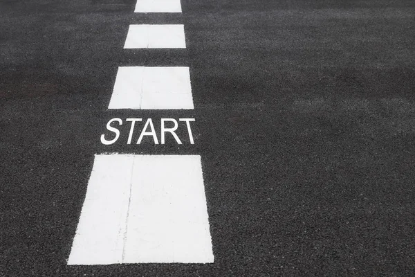 Start word on asphalt road surface with marking lines — Stock Photo, Image