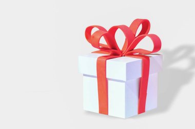 Beyaz hediye kutusu ve kırmızı kurdele beyaz arka planda, kutlama kavramı