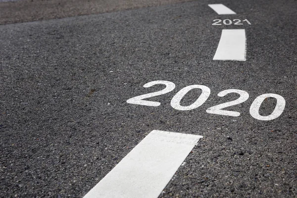 2020 to 2021 on black asphalt road and white marking lines, happy new year and road to success concept