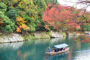 Kyoto, Japonya - 26 Kasım 2019: Japonya 'nın Kyoto kentindeki Arashiyama bölgesinde sonbahar mevsiminde Hozu Nehri' nde gezgin botu