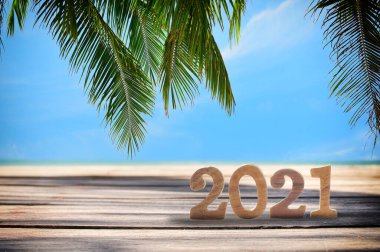2021, tropikal plaj arka planındaki tahtalar, doğal fırın konsepti ve mutlu yaz tatili fikri.