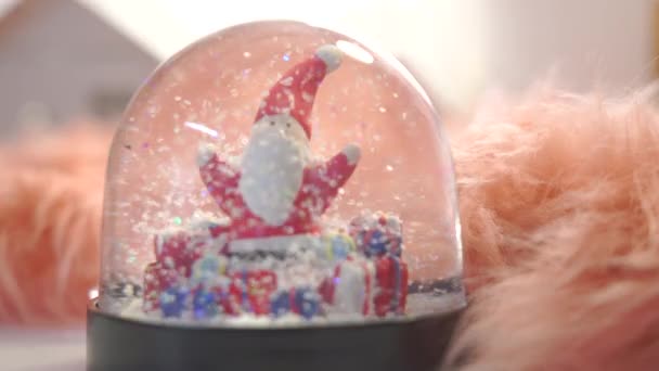 クリスマスのテーマと人工雪でいっぱいのクリスタルボール 雪の世界の中のサンタのクローズアップ — ストック動画