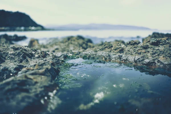 Spiaggia roccia e pietra da mostrare con spiaggia sullo sfondo — Foto Stock