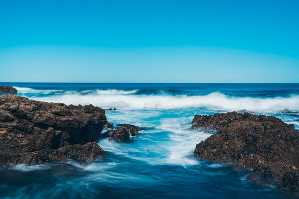 Длительное обнажение морской волны со скалой
