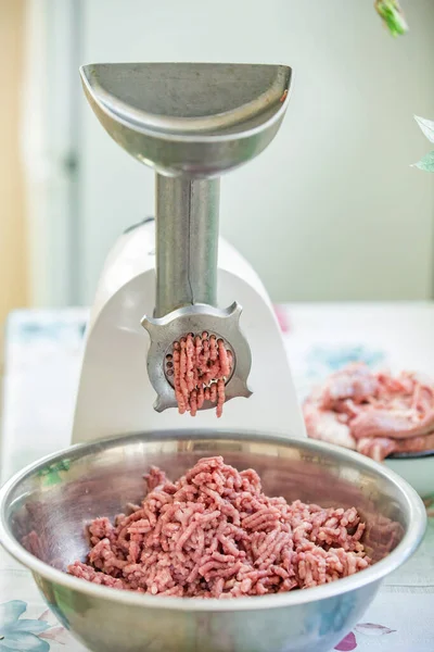 Fresh minced meat twisted, great design for any purposes. Meat grinder in a beautiful kitchen .Minced meatballs in a bowl — Stock Photo, Image