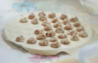  Ravioli yapmak için hazırlanmış çiğ et. Beyaz arka planda ravioli üretimi. Yemek pişirme konsepti. Sağlıklı yiyecekler. İnsanlar yemek yapıyor. Sağlıklı taze besin