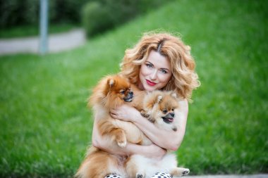  Güzel kızıl saçlı kadın kollarında iki küçük tükürük köpeği tutuyor. Mutlu bir çocuk portresi Özgür bir kadın