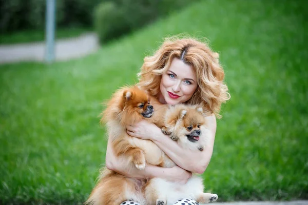  Güzel kızıl saçlı kadın kollarında iki küçük tükürük köpeği tutuyor. Mutlu bir çocuk portresi Özgür bir kadın