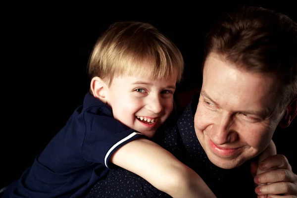 portrait of father with son on black background emotions