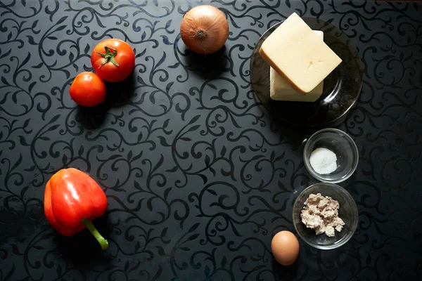 Siyah masa arkaplanlı pizza ürünleri peynir tereyağlı sosis mayalı domates biberi