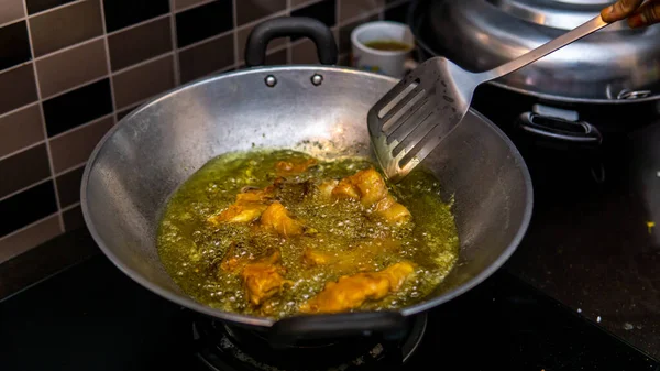 부엌에서 기름을 통에서 생닭고기를 가까이 수있다 주걱을 사용하여 닭고기를 손으로 — 스톡 사진