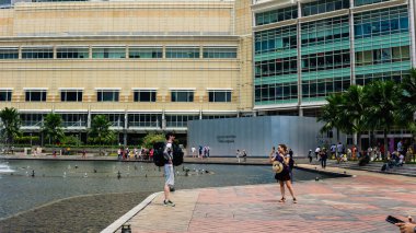 Kuala Lumpur, Malezya - 30 Temmuz 2019: Sırt çantalı kimliği belirsiz turist Petronas İkiz Kuleleri 'ndeki Suria KLCC' nin önünde fotoğraf çekiyor.