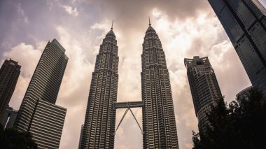 Kuala Lumpur, Malezya - 30 Temmuz 2019: Petronas İkiz Kuleleri veya KLCC 'nin akşam saatlerinde düşük açılı görüntüsü.