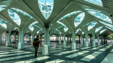 Kuala Lumpur, Malezya - 30 Temmuz 2019: KLCC Camii 'nin ya da Kuala Lumpur' daki Mescid as Syakirin 'in güzel iç tasarım çatısı altında yürüyen kırmızı sırt çantalı tanımlanamayan Müslüman adam.