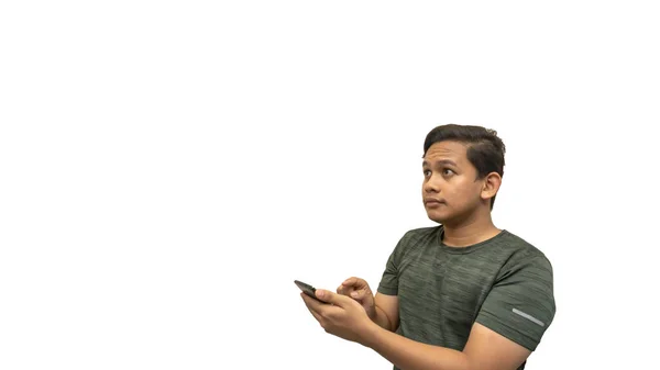 年轻的亚裔马来人用智能手机 用孤独的白色背景看着空旷的空间 脸上洋溢着自信的笑容 网上广告概念 — 图库照片