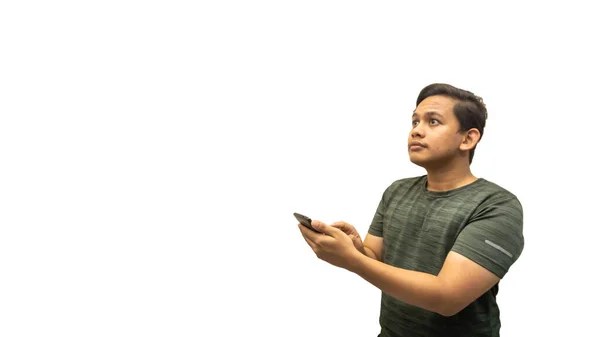 年轻的亚裔马来人用智能手机 用孤独的白色背景看着空旷的空间 脸上洋溢着自信的笑容 网上广告概念 — 图库照片
