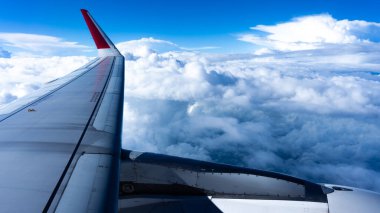 Uçağın penceresinden görünen beyaz bulutlu gökyüzü. Bu AirAsia uçağı, en ucuz uçuşlardan biri..