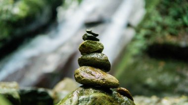 Sabah, Malezya 'daki yağmur ormanlarının arka planında şelale olan taşlar heykeli.