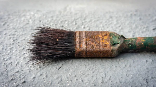 近景的旧生锈的画笔与灰色背景 刷柄上的油漆纹理脱落 — 图库照片
