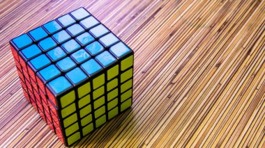 Bangi, Malezya - 24 Temmuz 2019: 5x5 Rubik Küpü ahşap masa arkasında.