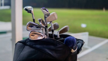 Gece boyunca golf sahasında çeşitli golf kulüplerinin yakın görüntüsü yalvarıyor. Gürültü fotoğrafı ışığa maruz kaldığı için..