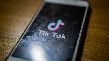 Bangi, Malezya - 29 Eylül 2019: Ahşap masa arkaplanlı bir android akıllı telefonundaki Tik Tok logosunun yakın görüntüsü. Kısa dudak senkronizasyonu, komedi ve yetenek videoları oluşturma ve paylaşma uygulamaları.