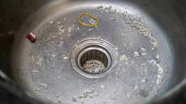 Clogged sink with food leftover. Uncleaned kitchen sink with dirty food leftover.