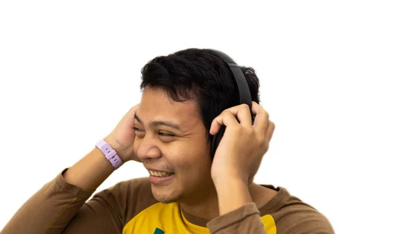 在欣赏音乐的同时 还带着幸福的亚洲男人的近照 他双手拿着耳机 背景是白色的 孤立的 — 图库照片