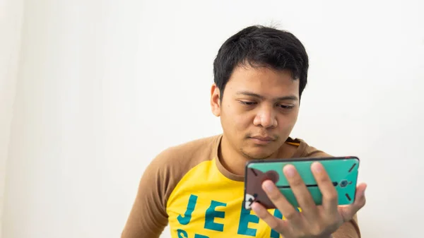马来西亚赛博贾亚 2020年3月8日 一个拿着智能手机的马来人的肖像正在屏幕上观看一些带有白色背景的视频 — 图库照片