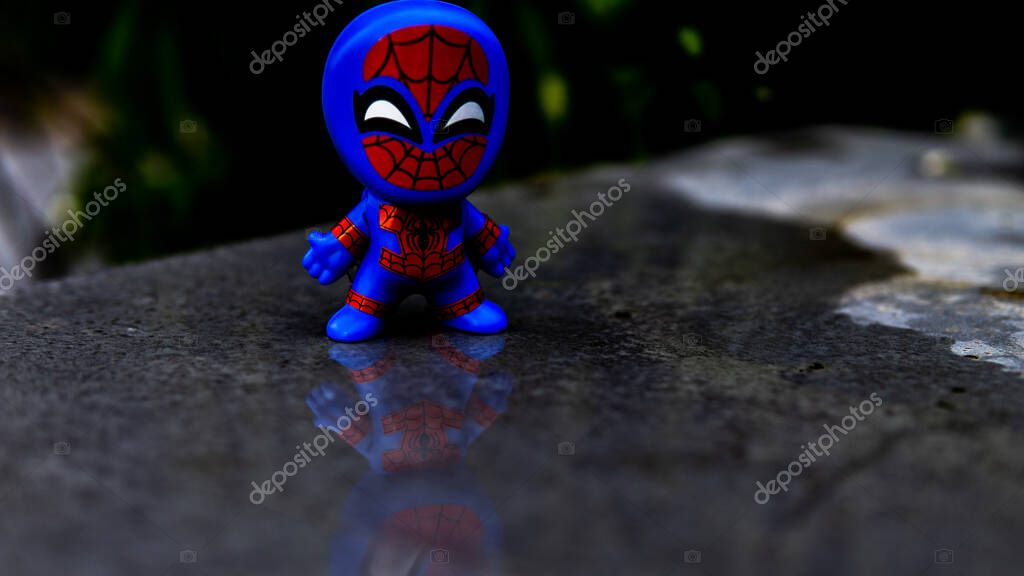 Selangor , Malaysia - March 28, 2019: McDonald's Spiderman toy watching his reflection on the water puddles.