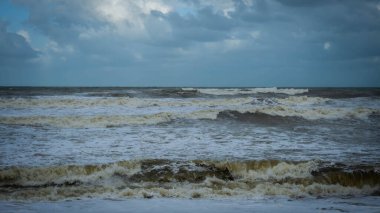 Muson mevsiminde Kuala Terengganu 'daki Batu Buruk Sahili' ni büyük dalgalar vurdu. Okyanustan esen güçlü rüzgar kıyı şeridini vurdu. Karanlık ve bulutlu bir arka plan. Denizle oynamak tehlikelidir. Fırtınalı deniz.