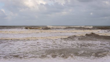 Muson mevsiminde Kuala Terengganu 'daki Batu Buruk Sahili' ni büyük dalgalar vurdu. Okyanustan esen güçlü rüzgar kıyı şeridini vurdu. Karanlık ve bulutlu bir arka plan. Denizle oynamak tehlikelidir. Fırtınalı deniz.