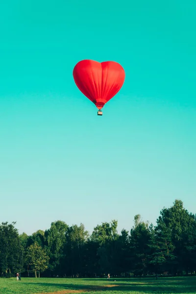 Globo de aire caliente rojo en forma de corazón contra el cielo azul — Foto de Stock
