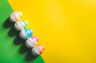 Sarı ve yeşil arka planda Paskalya yumurtaları.