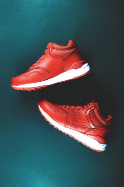 Mavi arka planda kırmızı spor ayakkabılar. Spor anlayışı ve sağlıklı yaşam tarzı.
