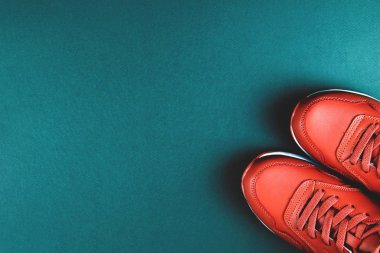 Mavi arka planda kırmızı spor ayakkabılar. Spor anlayışı ve sağlıklı yaşam tarzı.