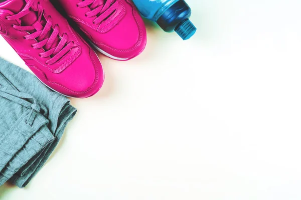 Pink sneakers, bottle for water and sport pants.