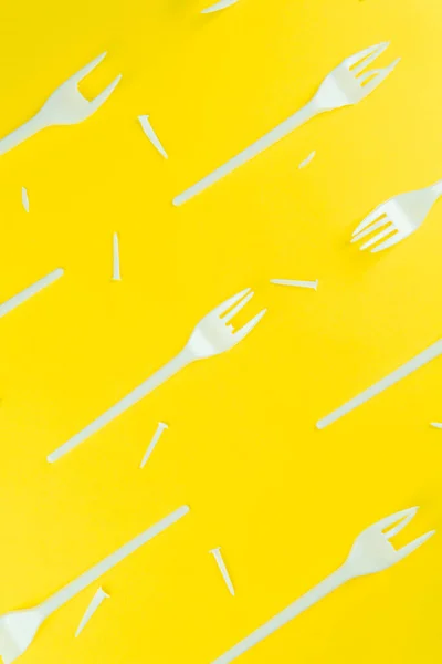 Pattern of broken plastic forks on a yellow background. — Stock Photo, Image