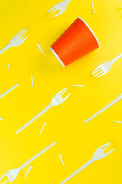 Patrón de horquillas de plástico rotas y copa de plástico sobre un fondo amarillo . — Foto de Stock
