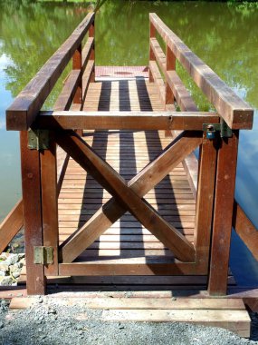 Bir su birikintisi üzerinde öngörülen küçük ahşap köprü