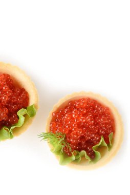 Beyaz arka planda yeşil salatalı hamur tartlarında kırmızı havyar.