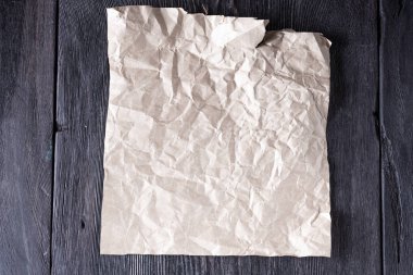 Kırsal tarzda ahşap gri bir masa üzerinde buruşuk bir Kraft kağıdı.