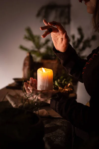 Ortaçağ elbisesi giymiş bir kadın elinde yanan beyaz bir mum tutuyor. Gizemli cadı. — Stok fotoğraf