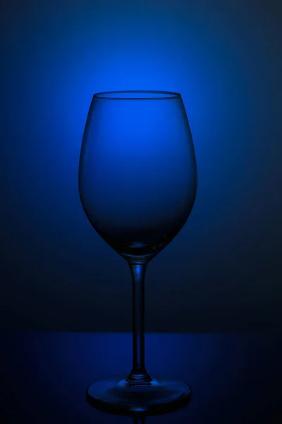 Verre à vin sur fond bleu. plats sur le dégagement sur un fond bleu — Photo