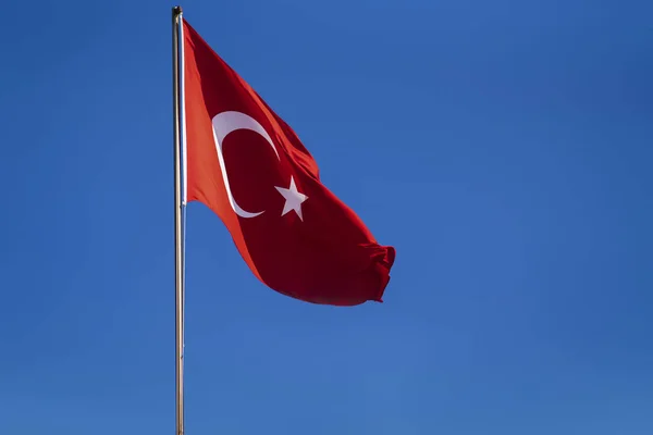 Turkiets röda flagga mot den blå himmel som flaggan växer fram i vinden. röd rektangel med vit stjärna och vit halvmåne. — Stockfoto