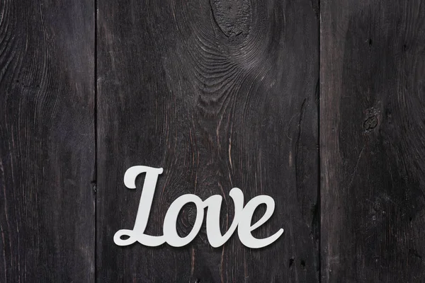 The word Love is a wood product on a wooden gray background, as a concept of love, a symbol. — Stock Photo, Image