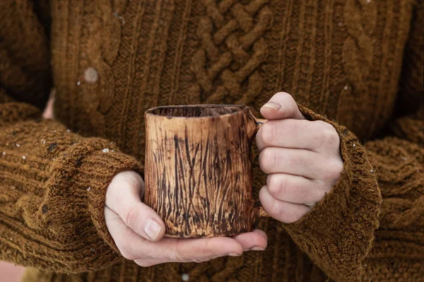 Woman in a knitted orange-brown sweater holds a mug in her hands — Stock Photo, Image