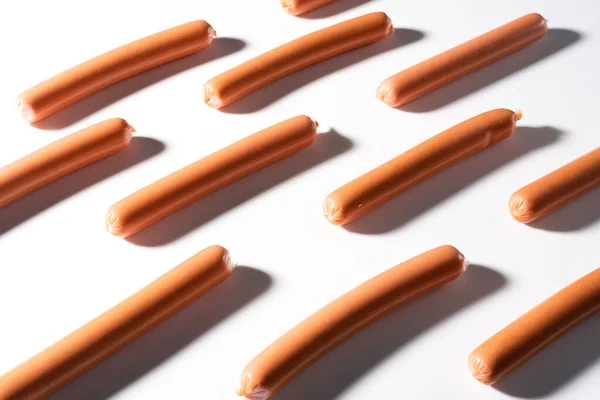 Small sausages on a white background in a row — Stock Photo, Image