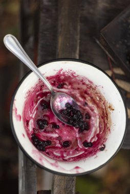 Sonbaharda dışarıda beyaz bir demir bardakta kuşüzümü reçeli. yemek pişirme süreci.