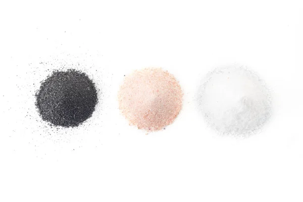 Три вида соли лежат на белом фоне - черный, розовый, белый — стоковое фото